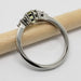 Side profile of 14k white gold ring with green sapphire and diamonds, beside a pencil
