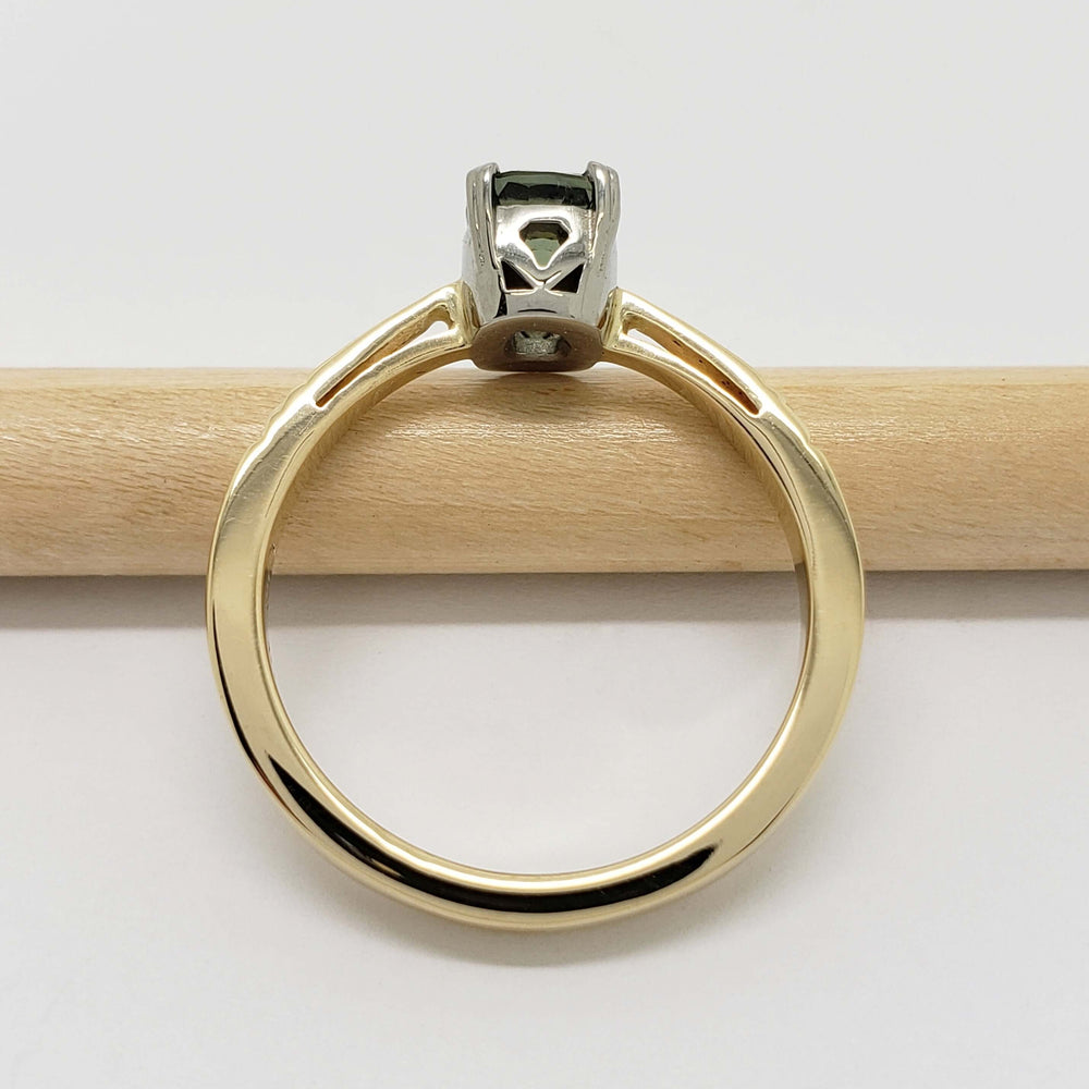 Side view of yellow and white gold ring with cushion cut green sapphire