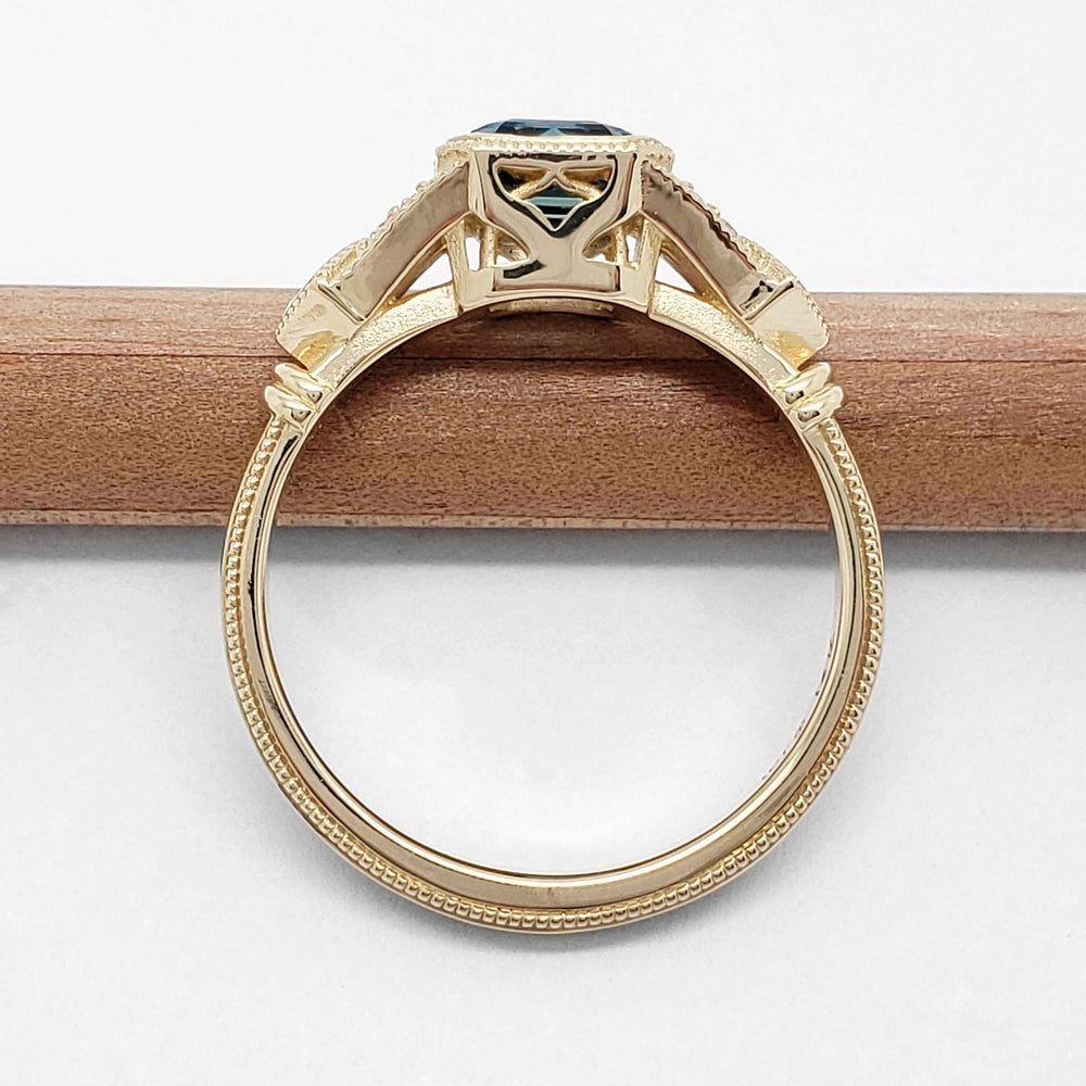Side profile of yellow gold ring showing under-gallery cutouts and millgrain details