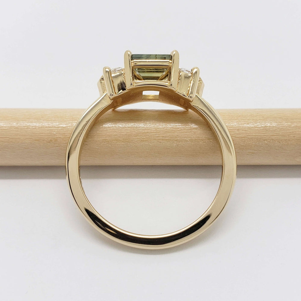 Side view of 14kt yellow gold ring with Australian sapphire and lab diamonds on a pencil