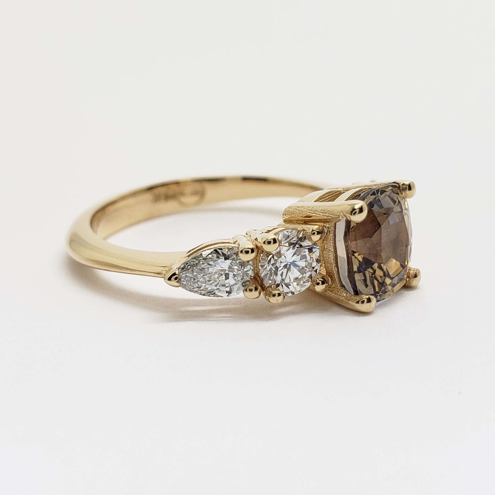 Side view of yellow gold ring with bi-colour sapphire and two lab diamonds on each side