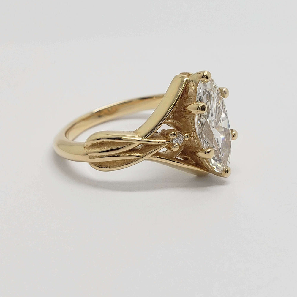 Side profile of yellow gold ring with interlaced design and lab-grown marquise-oval diamond