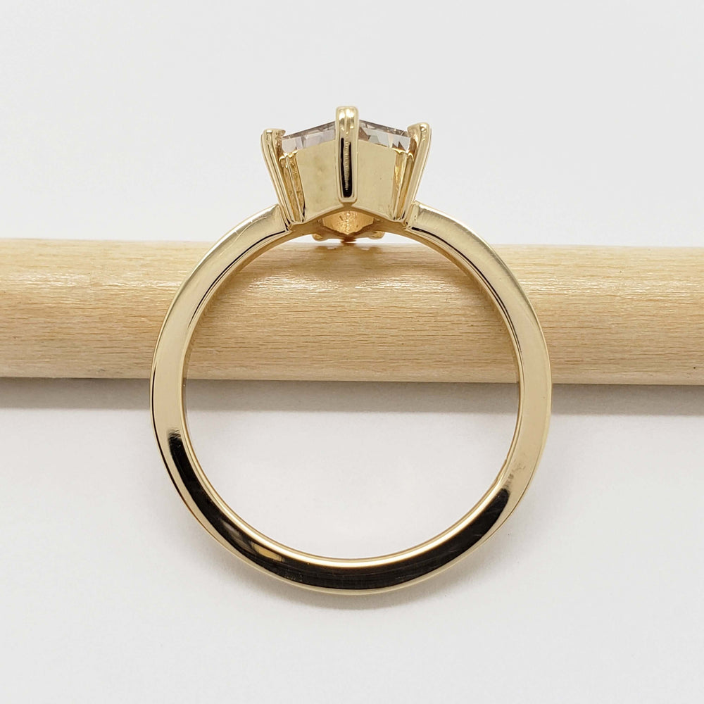 Side profile of yellow gold ring with shield cut grey sapphire, solitaire setting