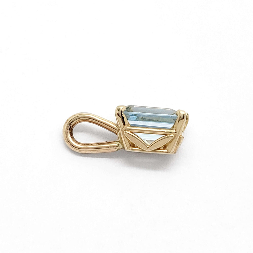 Side view of 10kt yellow gold pendant with emerald cut aquamarine, showing leaf cutouts