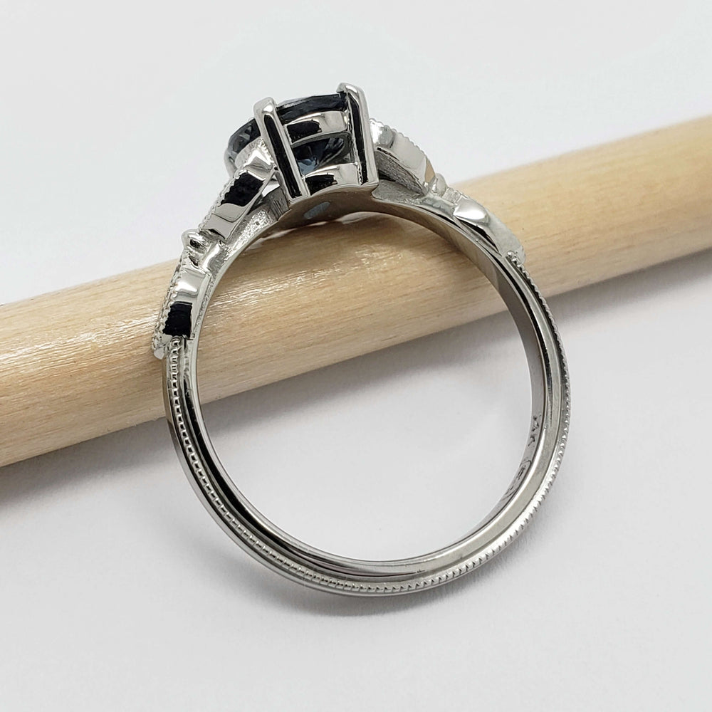 Side view of 14K white gold sapphire and diamond ring, highlighting the setting