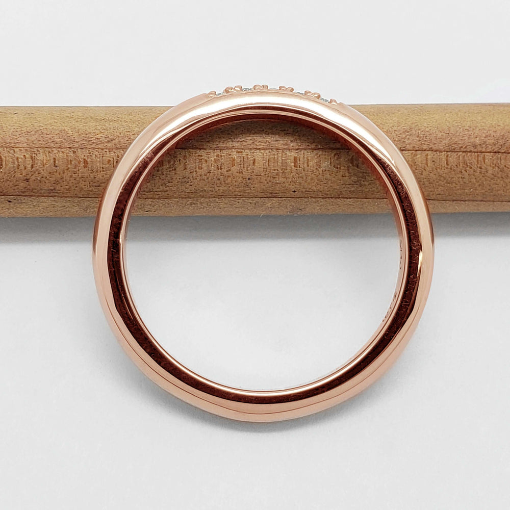 Side view of 14kt rose gold chevron wedding ring on a pencil