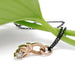 Side view of 14kt rose gold leafy pendant with champagne diamond and black chain