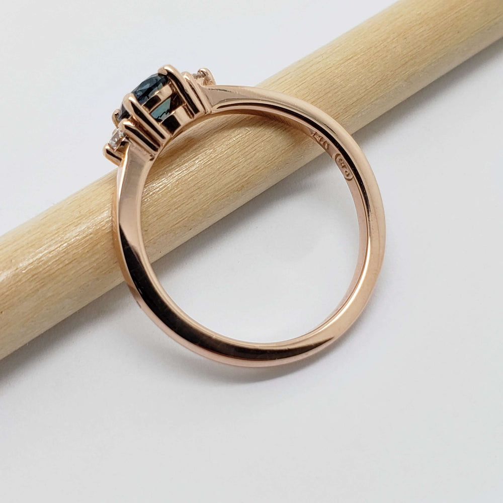 Side view of 14kt rose gold ring with blue sapphire and diamond accents