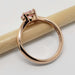 Side view of 14kt rose gold ring with pink sapphire in four-claw setting