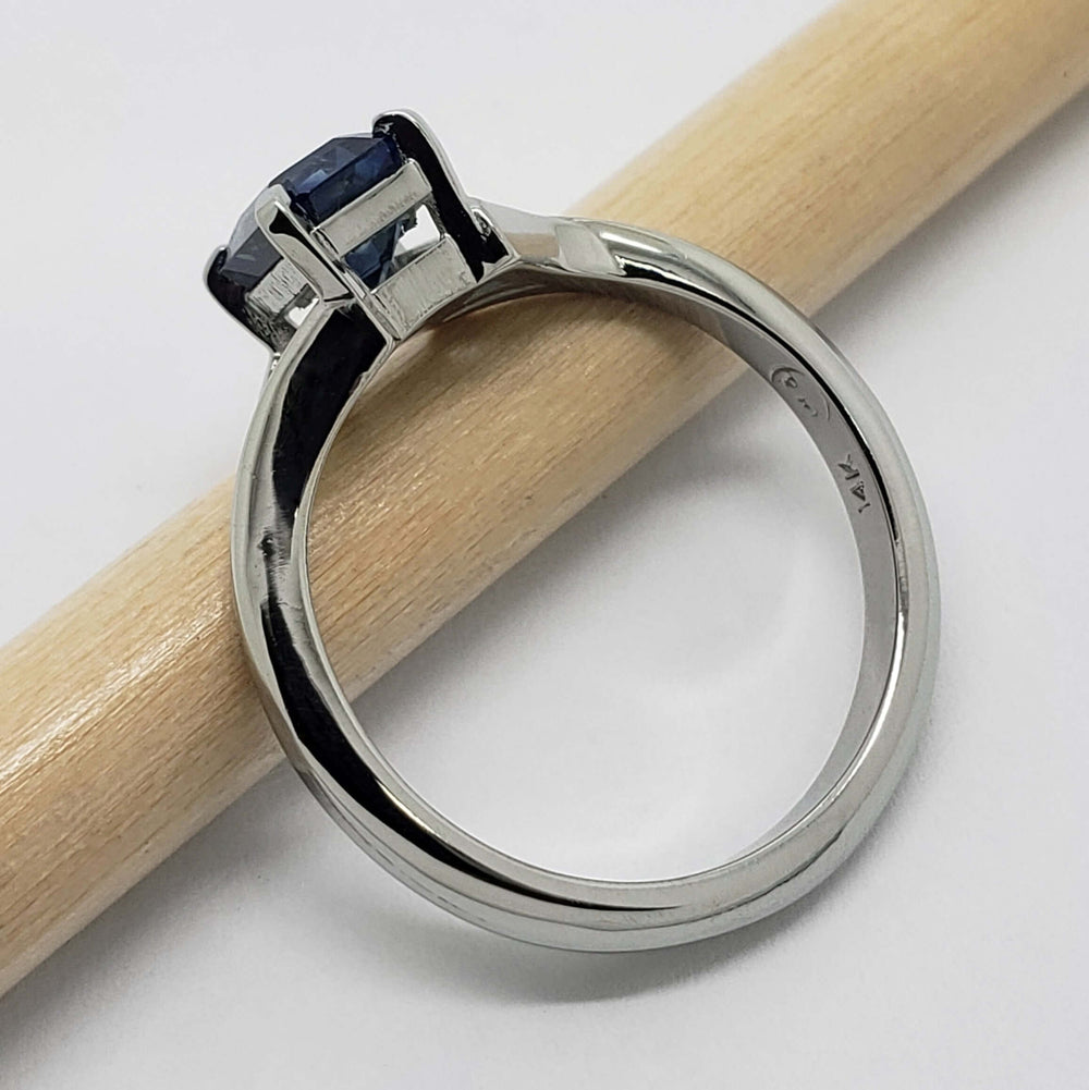 Side view of 14kt white gold Montana sapphire ring, band marked 14K, with pencil