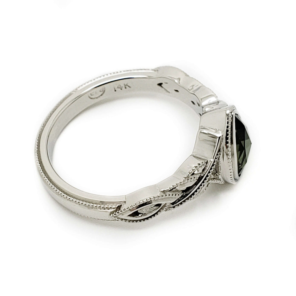 Side view of 14kt white gold engagement ring with green sapphire and detailed millgrain band