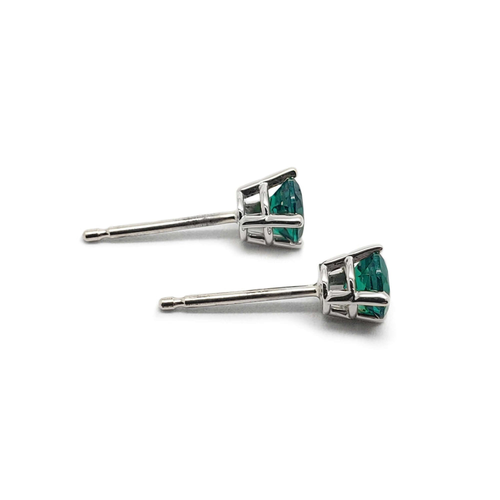 Side view of 14kt white gold lab emerald stud earrings showing claw setting
