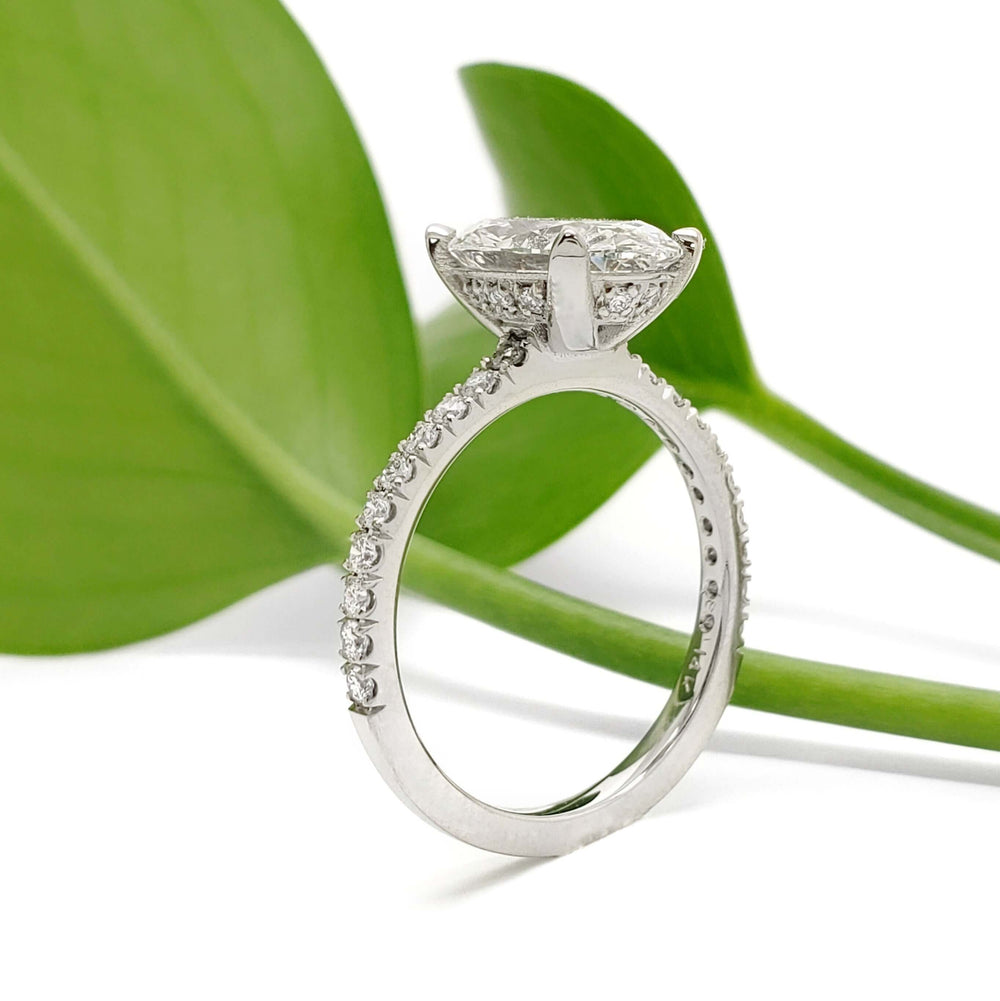 Side view of 14kt white gold oval lab diamond ring with pave band and hidden halo