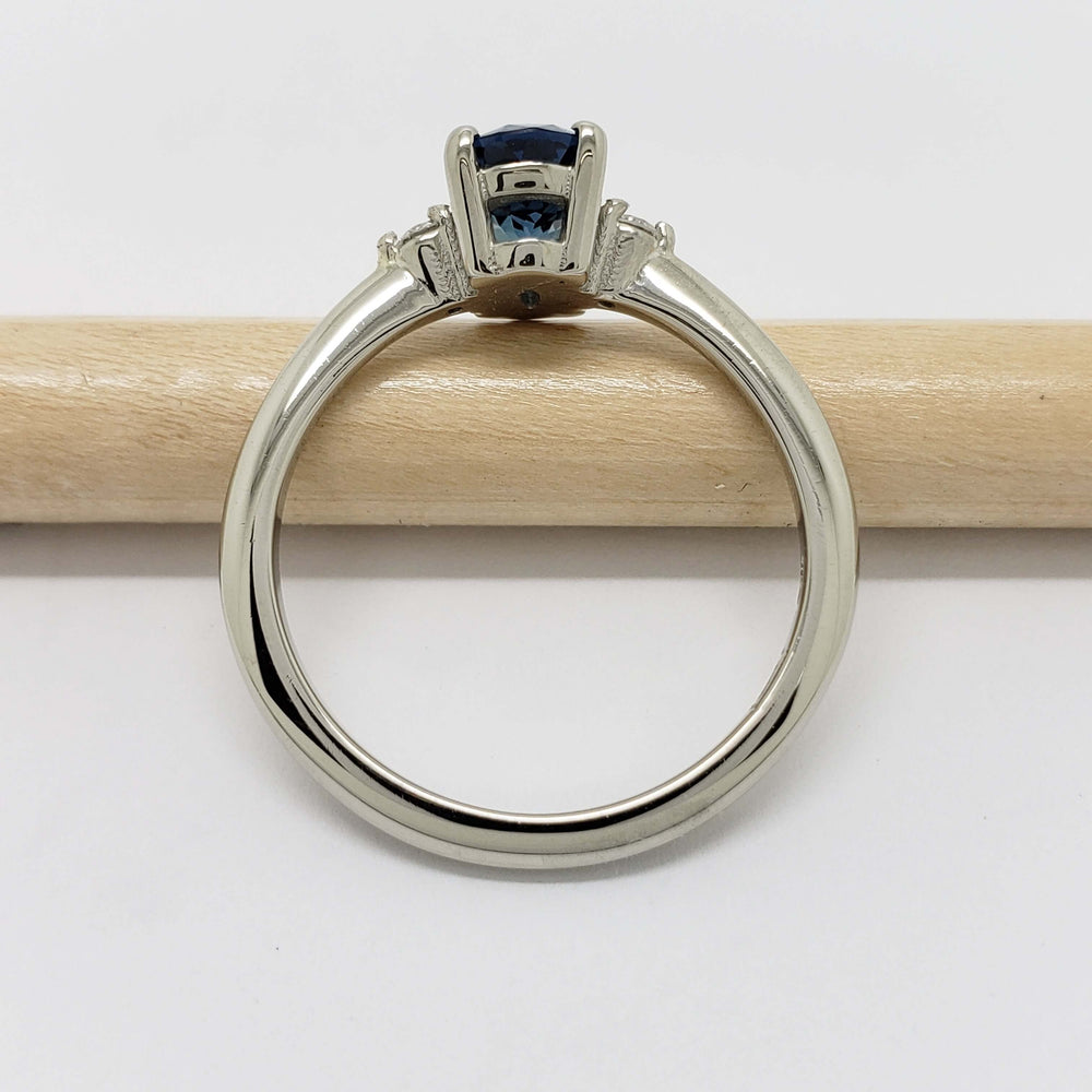 Side view of 14kt white gold ring with oval sapphire and diamond accents