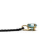 Side profile of 14kt yellow gold pendant with round blue zircon on black chain