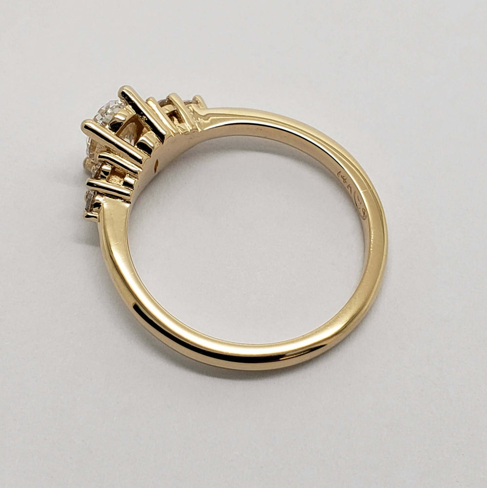 Side profile of yellow gold engagement ring with oval lab diamond setting