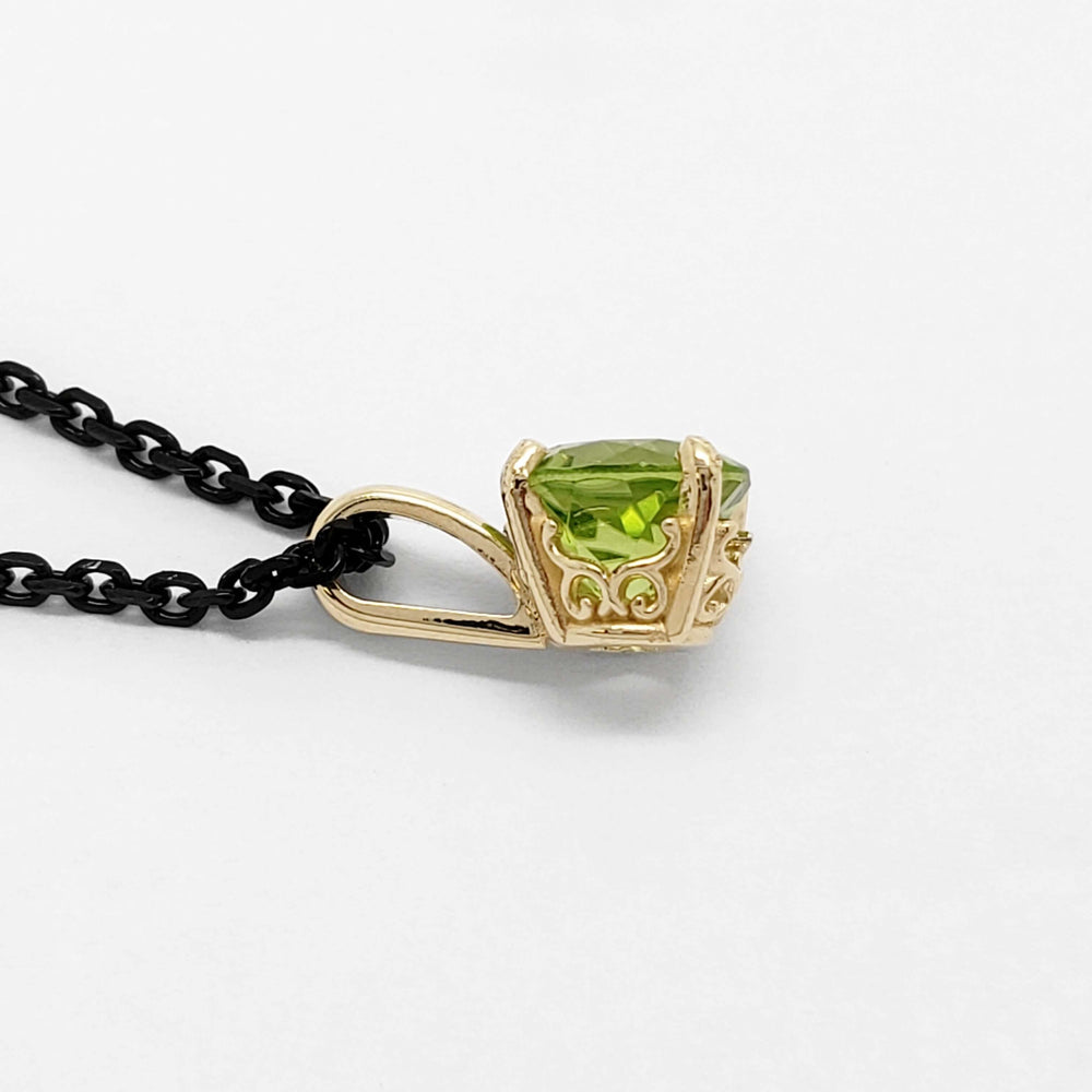 Side view of 14kt yellow gold filigree pendant with round green peridot