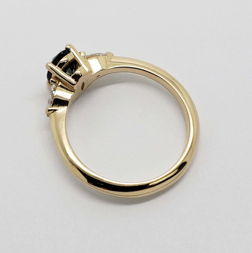 Side profile of 14kt yellow gold three-stone ring with blue sapphire and lab diamonds