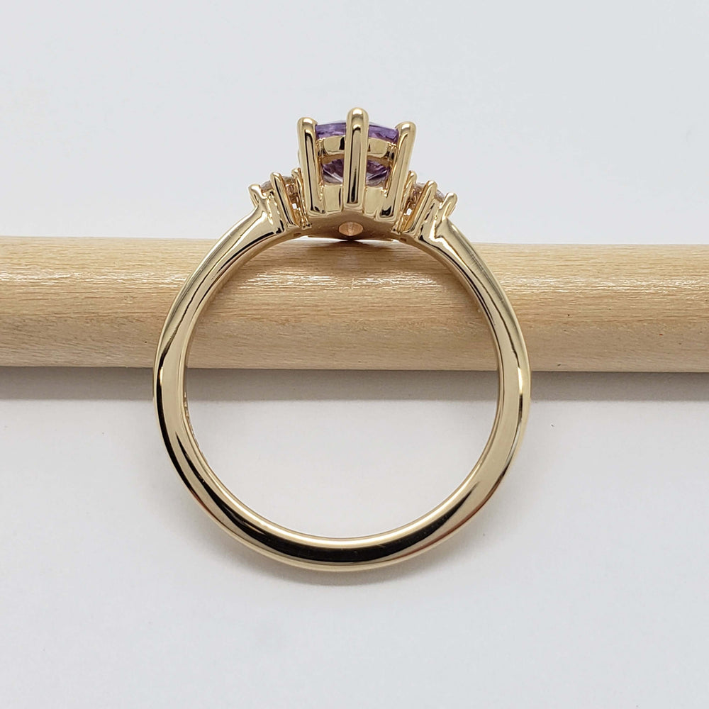 Side profile of 14kt yellow gold ring with lavender sapphire in claw setting