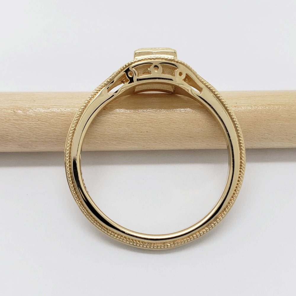 Side profile of 14kt yellow gold ring with millgrain detail and openwork gallery