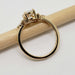 Side profile of 14kt yellow gold cluster engagement ring with oval lab diamond on a pencil
