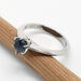 Side view of 14kt white gold Montana sapphire solitaire ring on a wooden pencil