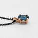 Side view of an oval London topaz pendant in 14kt rose gold on a black chain