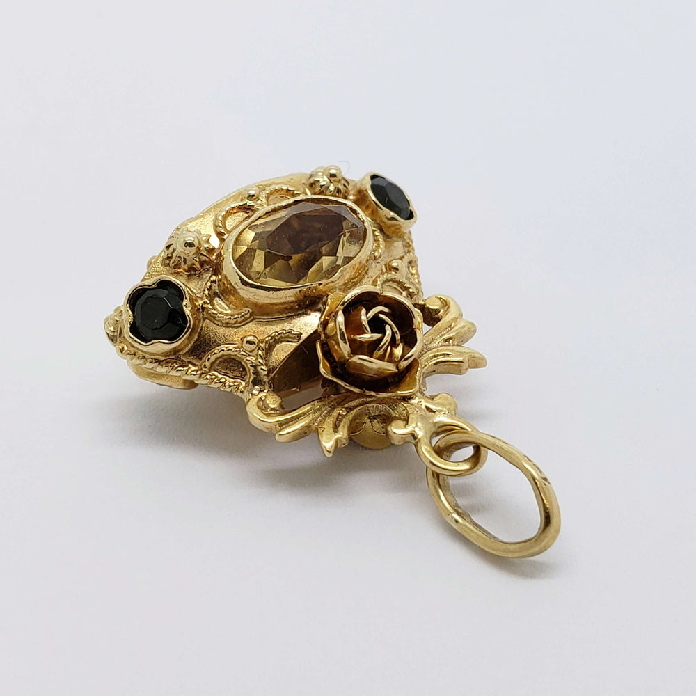 Detailed side view of 18kt yellow gold pendant with citrine, peridot, and rose motif