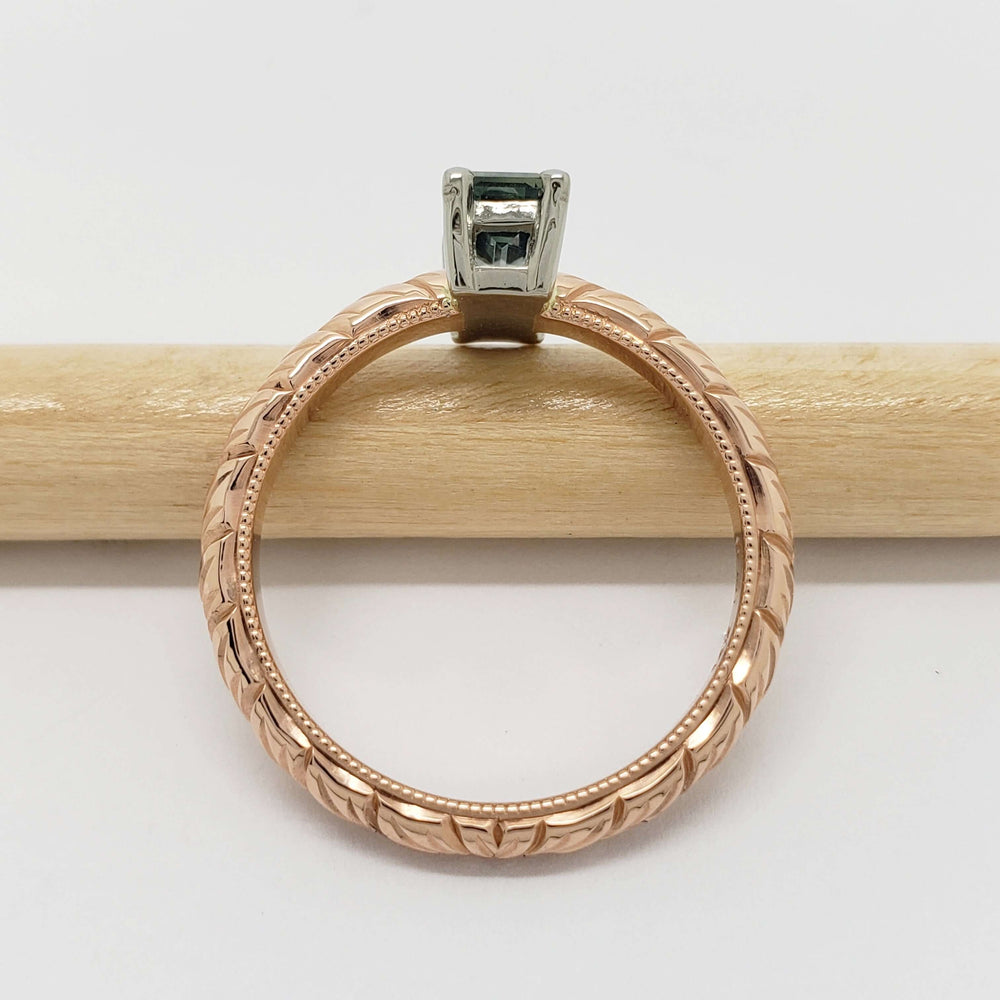Side view of engraved 14kt rose gold ring with teal Australian sapphire in white gold setting