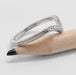 Side view of engraved 14kt white gold chevron wedding ring resting on a pencil