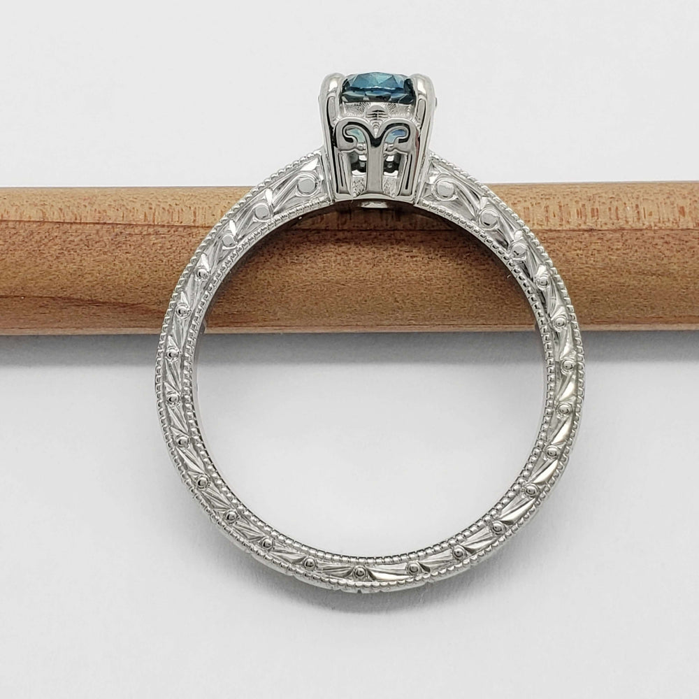 Side view of engraved 14kt white gold ring with blue Montana sapphire and diamond accents