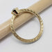 Side view of engraved 14kt yellow gold ring with bezel-set teal Montana sapphire