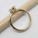 Side view of engraved 14kt yellow gold ring with marquise lab diamond, displayed on pencil
