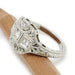 Side view of engraved 19kt white gold Art Deco diamond ring resting on a wooden stick