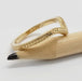 Side view of engraved yellow gold chevron wedding ring on a pencil