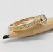 Side view of engraved yellow gold engagement ring with pave lab diamonds, on pencil
