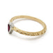 Side view of engraved yellow gold ring with pear ruby bezel set in white gold