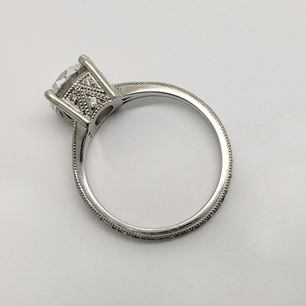 Side view of platinum engagement ring with detailed engraving and millgrain edges