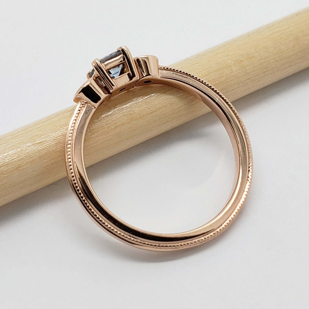 Side view of rose gold ring with blue Montana sapphire and diamonds, showing band detail