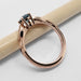Side profile of 14kt rose gold engagement ring with teal sapphire and leaf motif