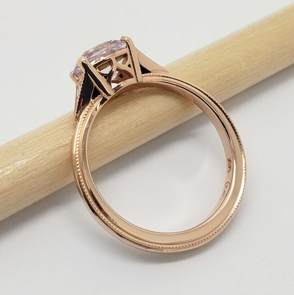 Side view of rose gold ring with cushion cut pink sapphire and intricate gallery