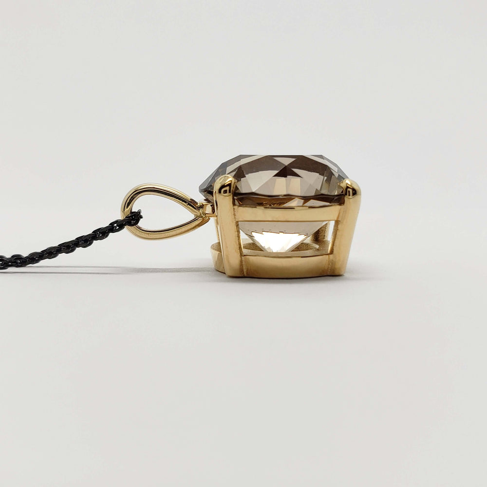 Side profile of smoky quartz pendant set in 14kt yellow gold with black chain