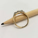 Side view of two-tone diamond wedding ring in yellow and white gold, resting on a pencil