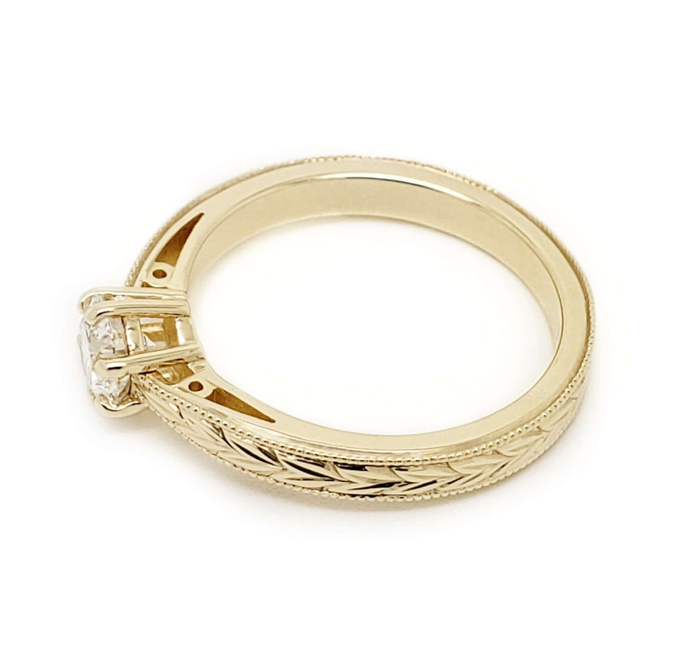 Side view of wheat engraved 14k yellow gold band with round Canadian diamond