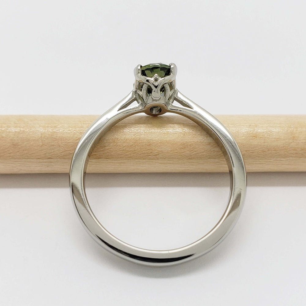Side view of white gold ring with basket-set Australian sapphire on a pencil