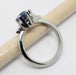 Side view of white gold ring with hexagon Montana sapphire and triangle diamonds