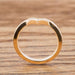 Side view of 14k yellow gold chevron wedding ring with millgrain edge on wood