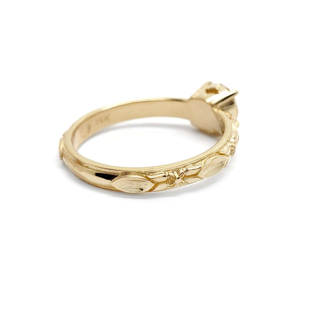 Side view of yellow gold engagement ring band showing engraved leaf details