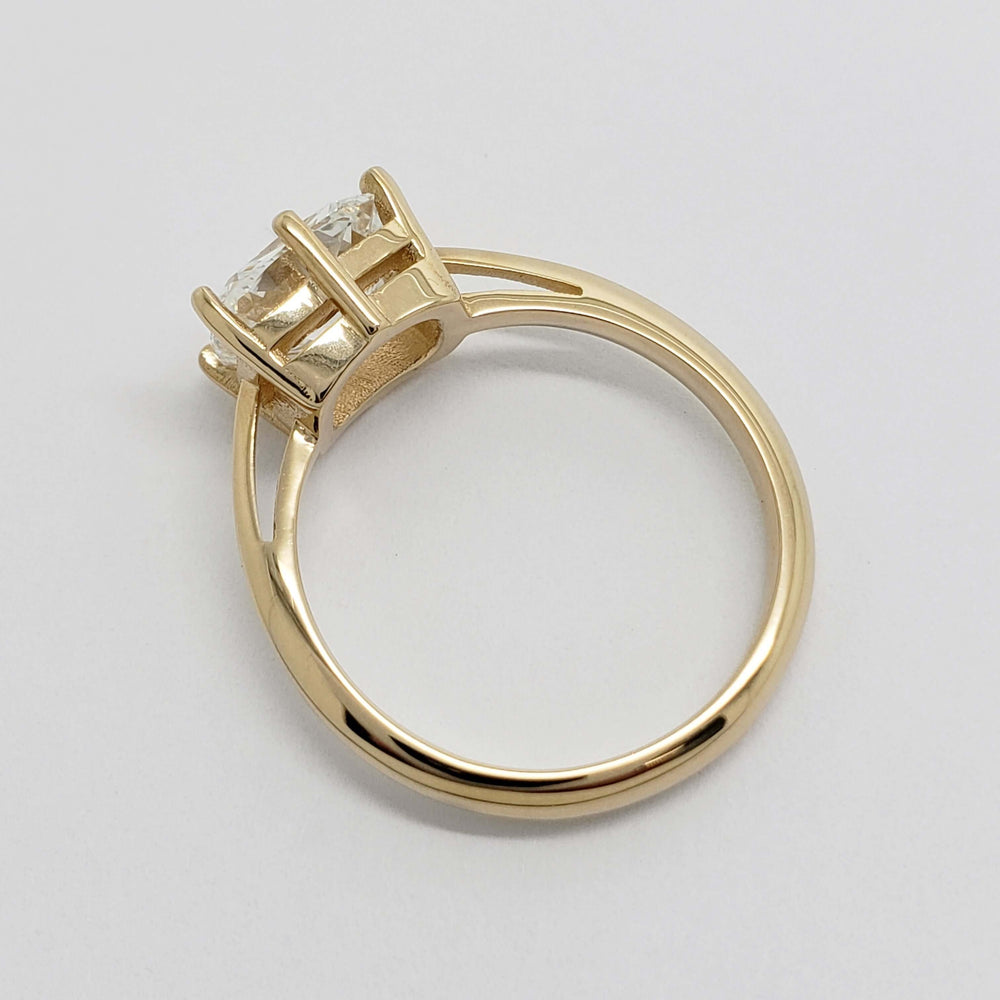 Side view of yellow gold engagement ring with cushion cut lab diamond and cathedral setting