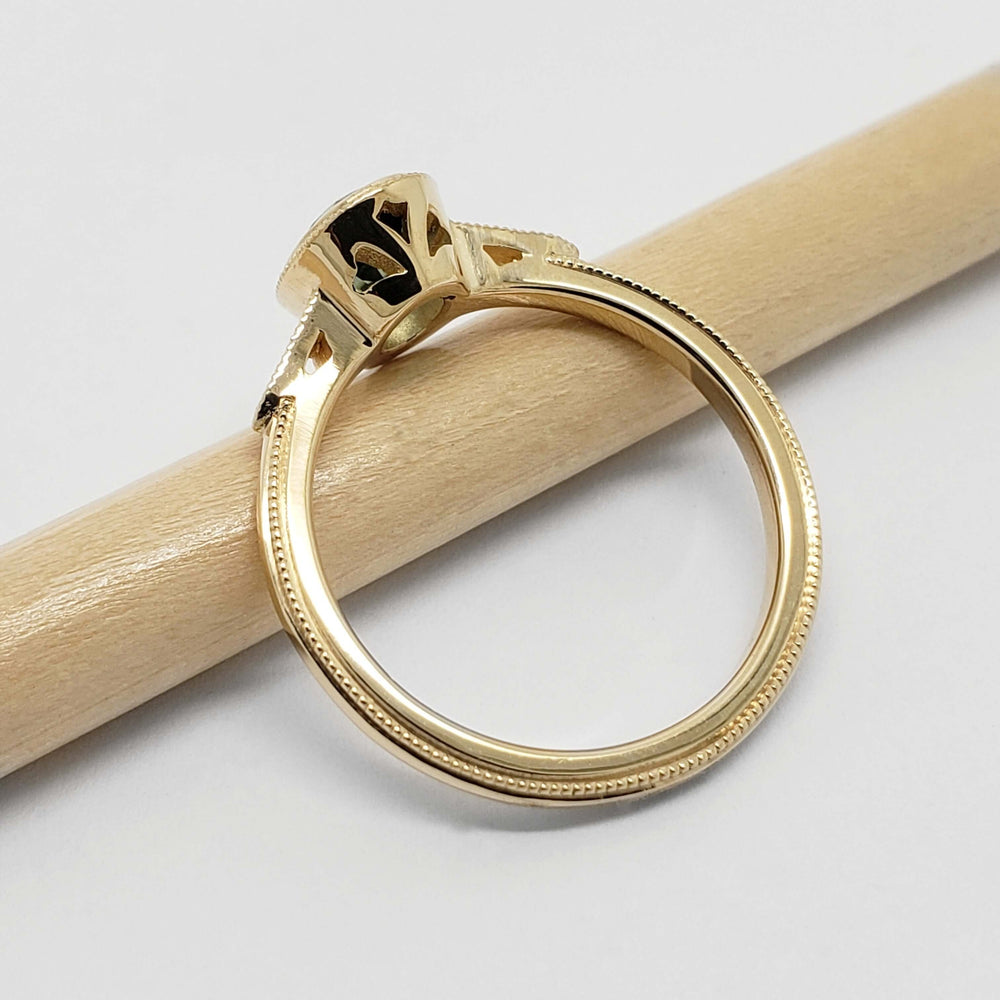 Side view of yellow gold engagement ring with oval lab diamond and cutout gallery